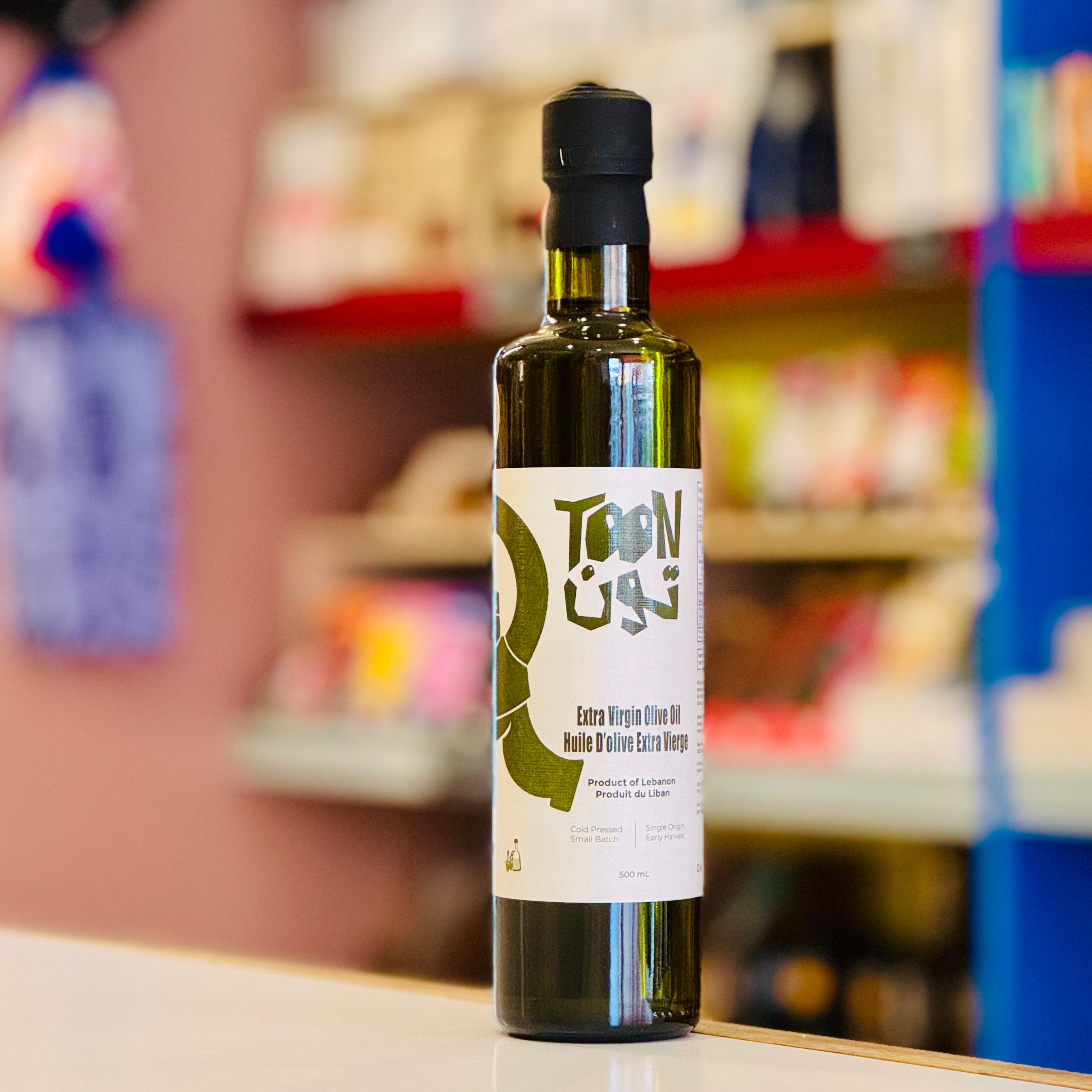 Bottle of Toon Uga olive oil on a shelf with a blurred store background