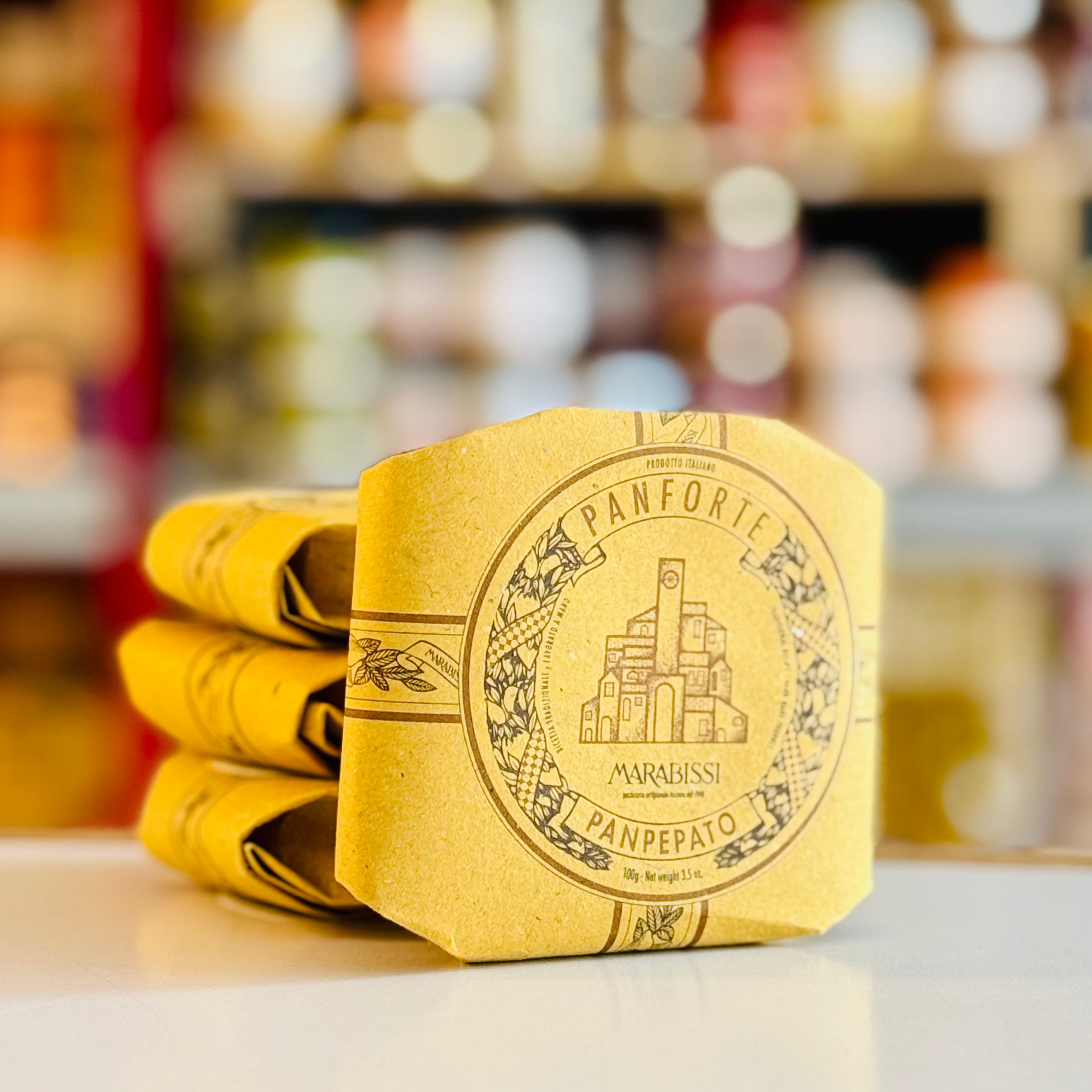 Stack of yellow Panforte Marabassi packaging on a blurred background