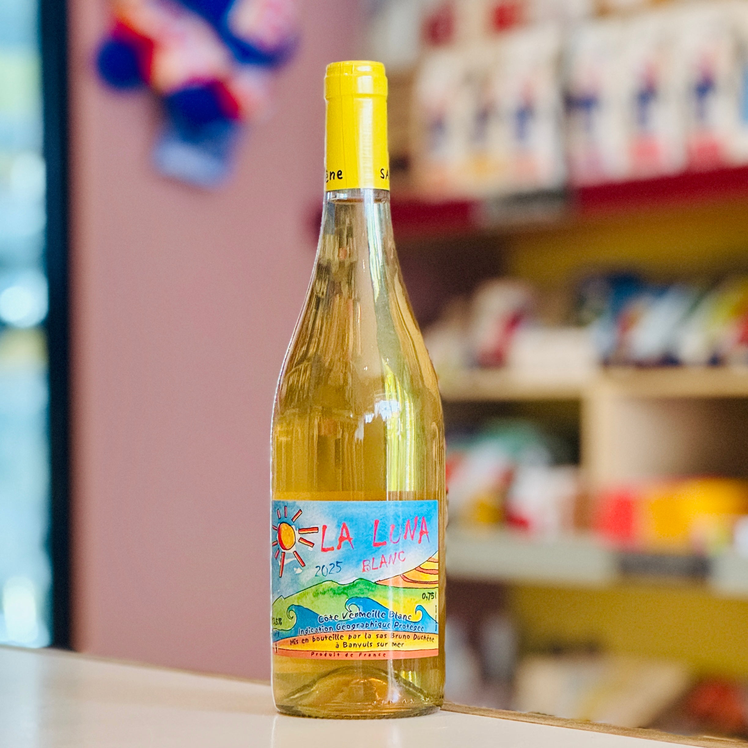 Bottle of white wine with a colorful label on a shelf in a store