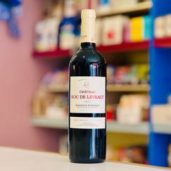 Bottle of Château Roc de Levraut 2022 wine on a shelf with blurred store shelves in the background