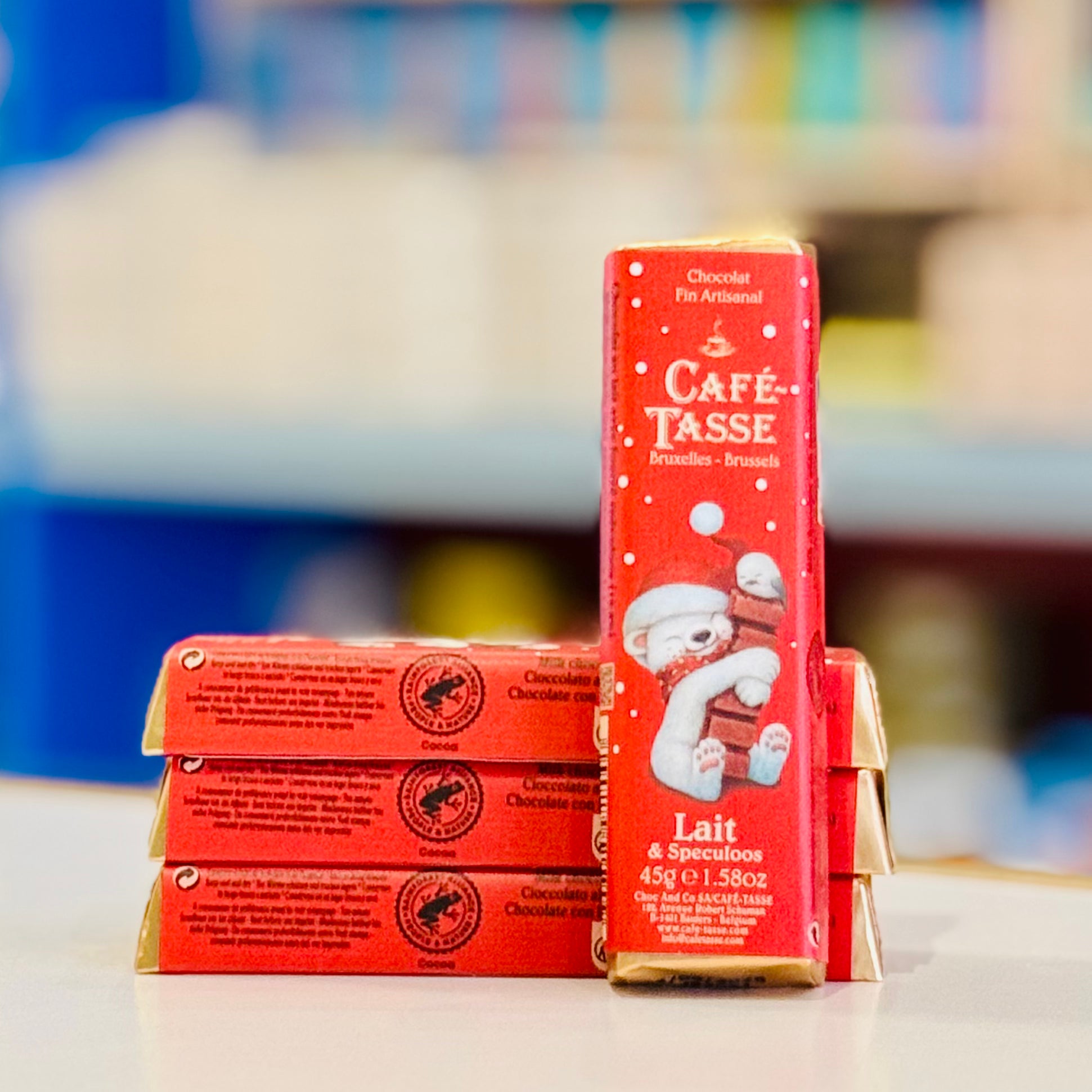 Red chocolate bar packaging with a bear illustration on a blurred background