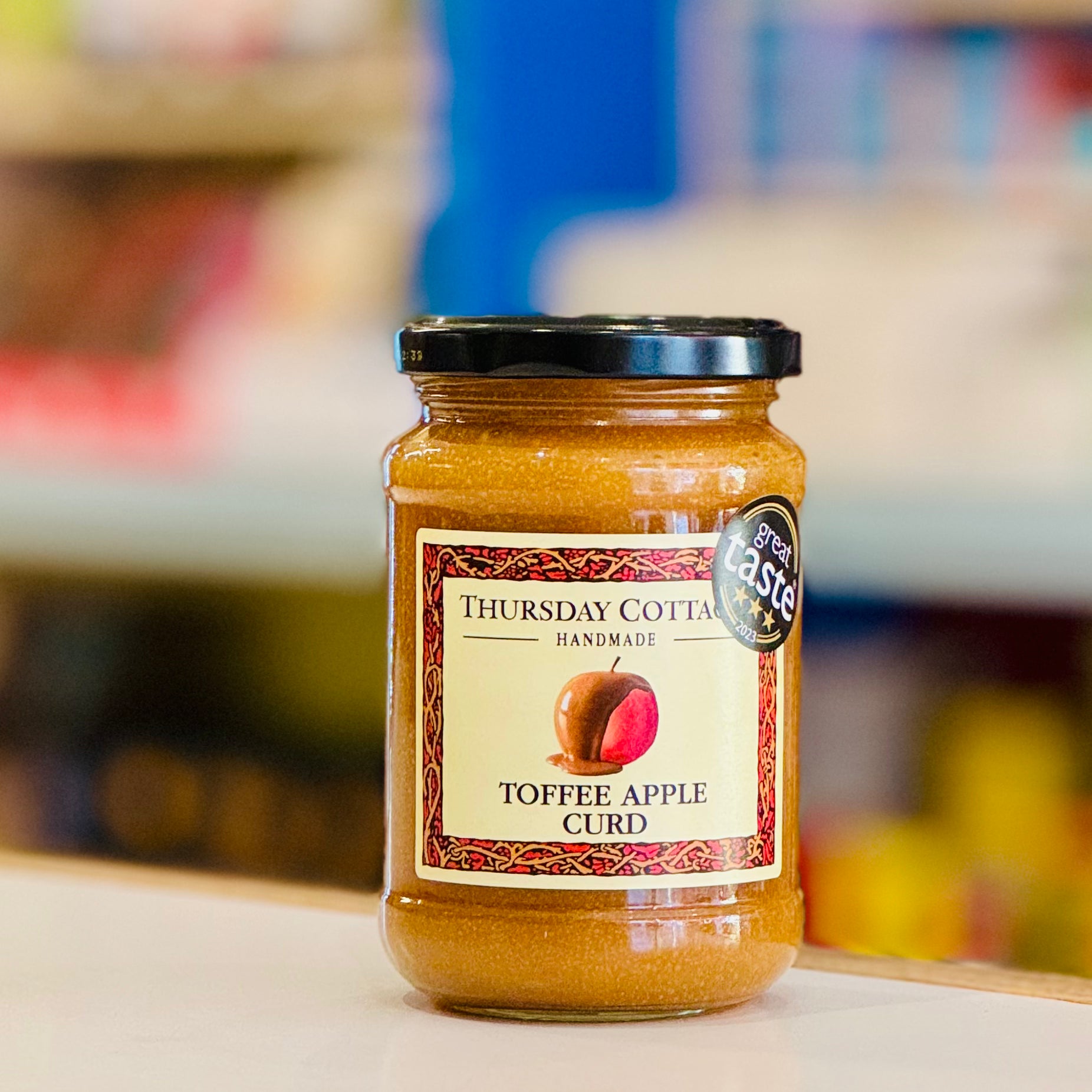 Jar of Toffee Apple Curd with a visible label on a blurred background