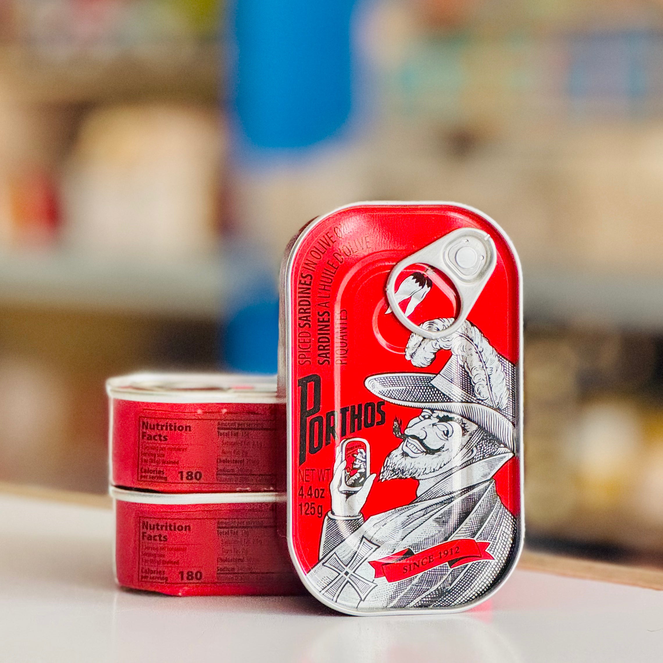 Two red tins with a vintage design on a blurred background