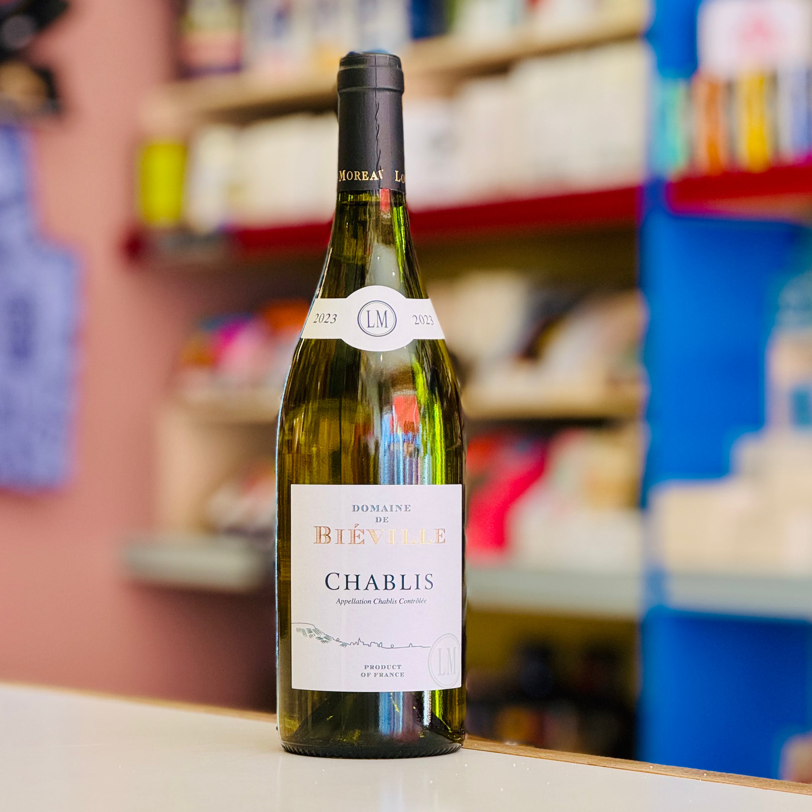 Bottle of Chablis wine on a shelf with blurred store background