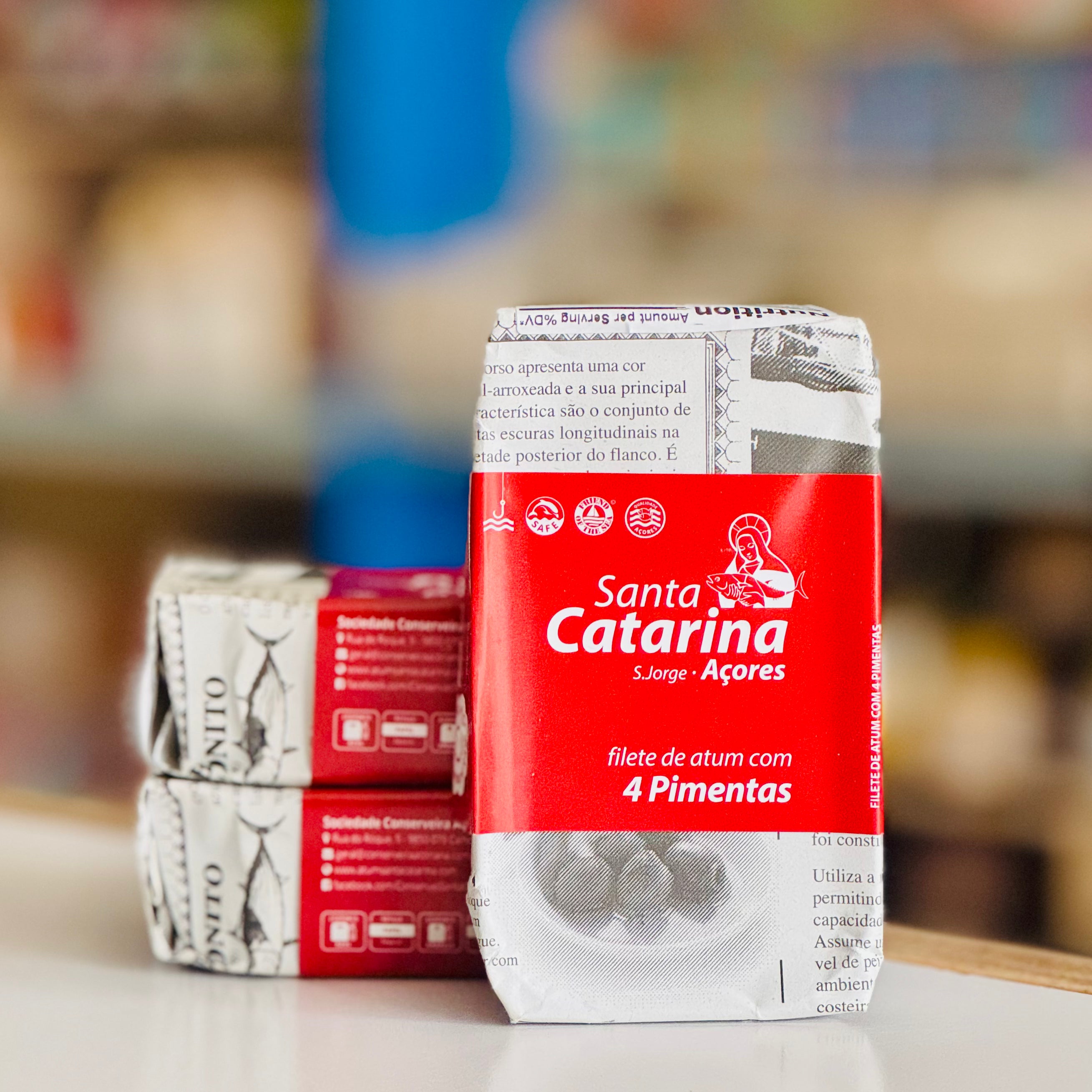 Red and white packaging of Santa Catarina with text on a blurred background
