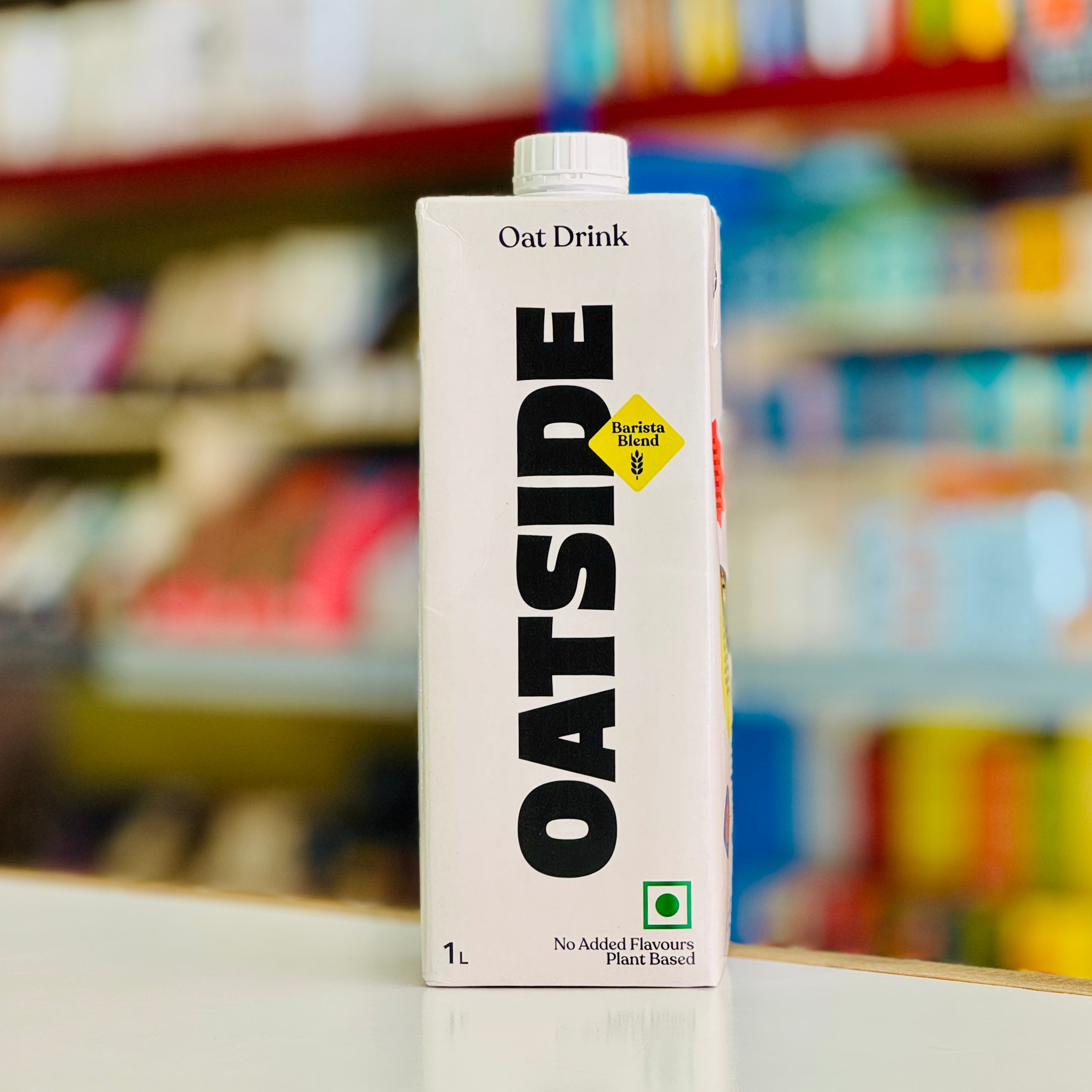 Oat Drink carton with 'Oatside' branding on a shelf in a store.