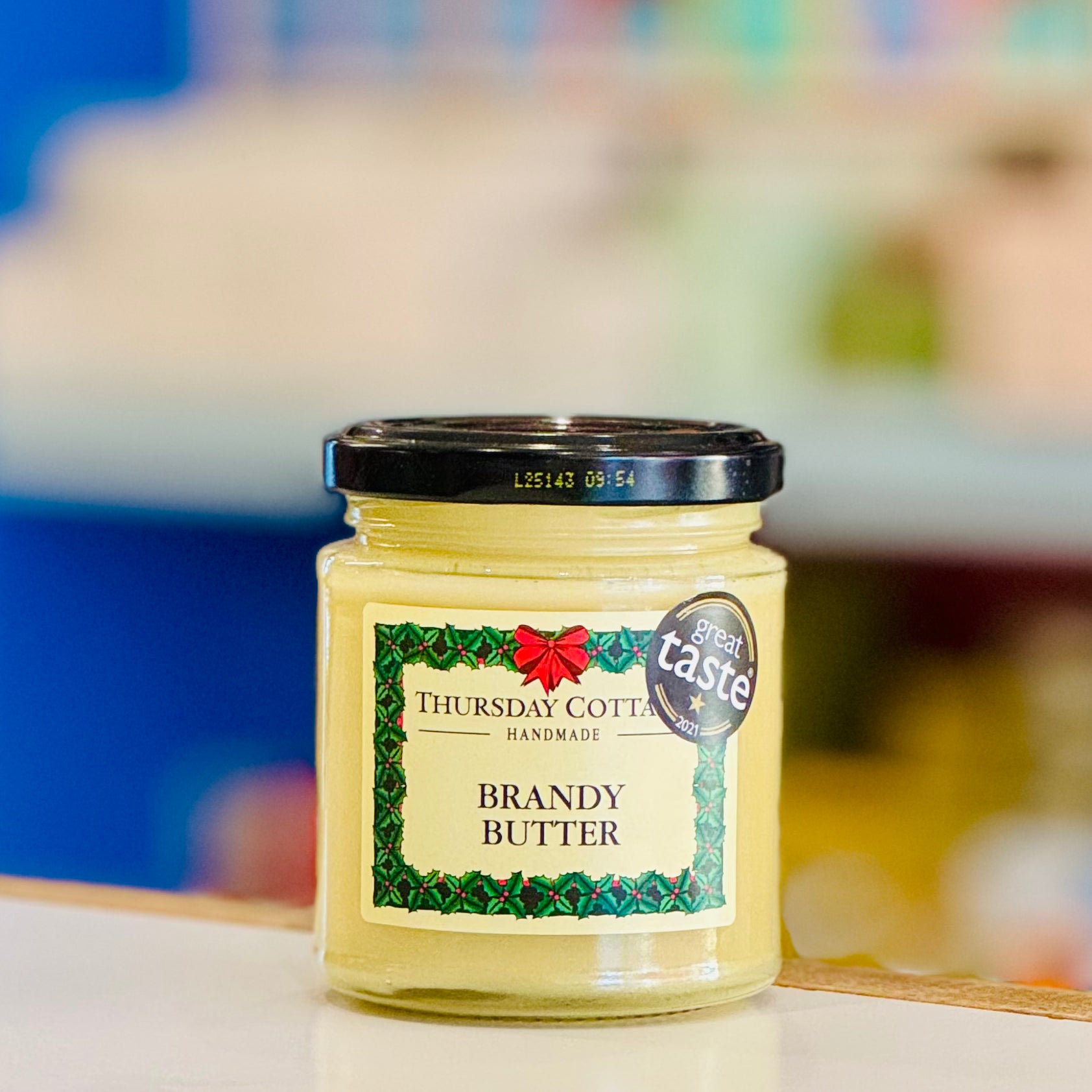 Jar of Thursday Cottages Brandy Butter with a blurred background