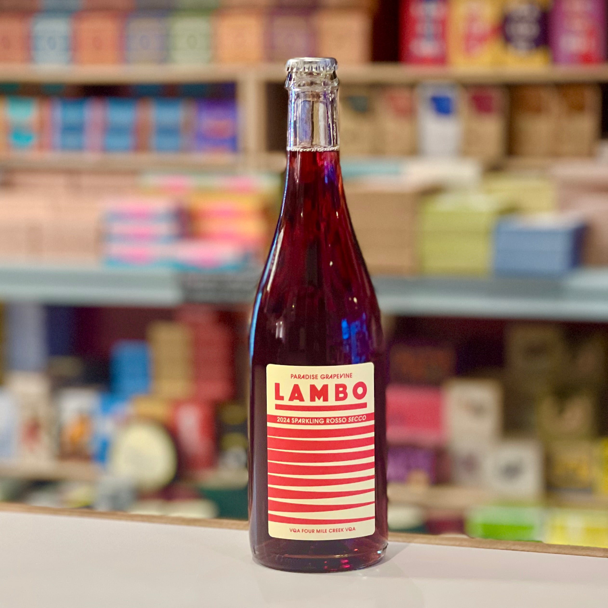 Bottle of Lambo sparkling berry drink on a shelf with colorful products in the background