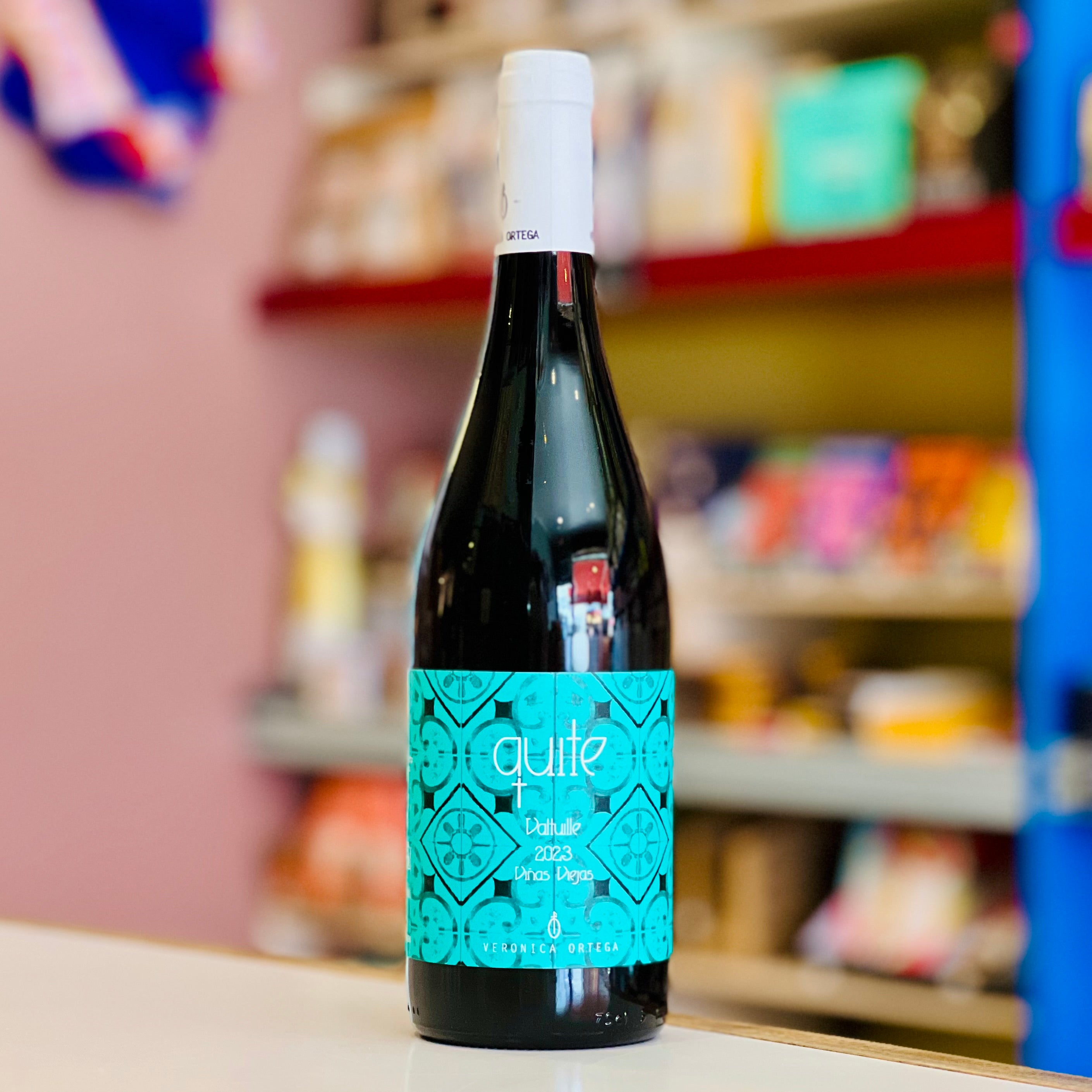 Bottle of wine with a turquoise label on a shelf in a store