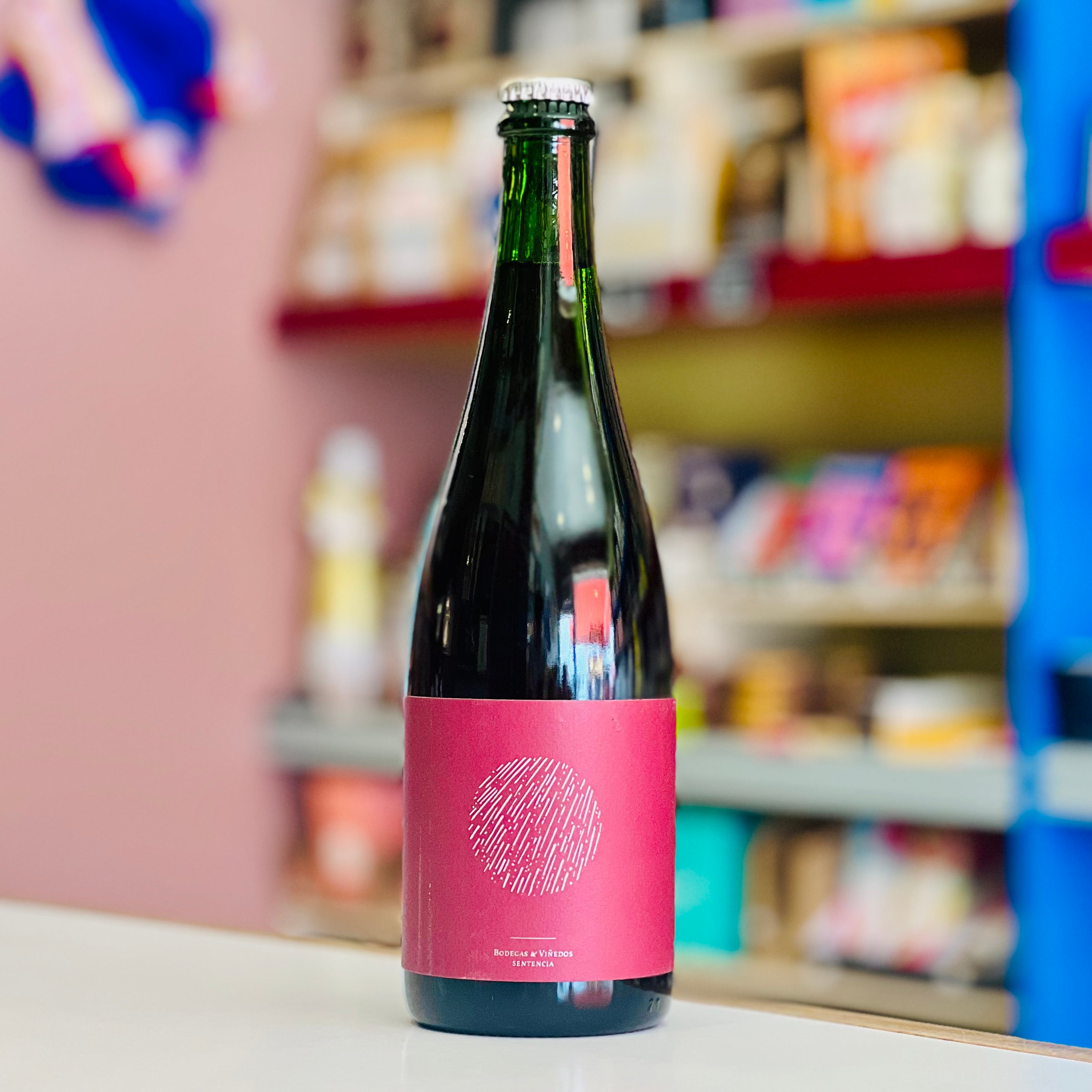 Bottle of wine with a pink label on a shelf in a store
